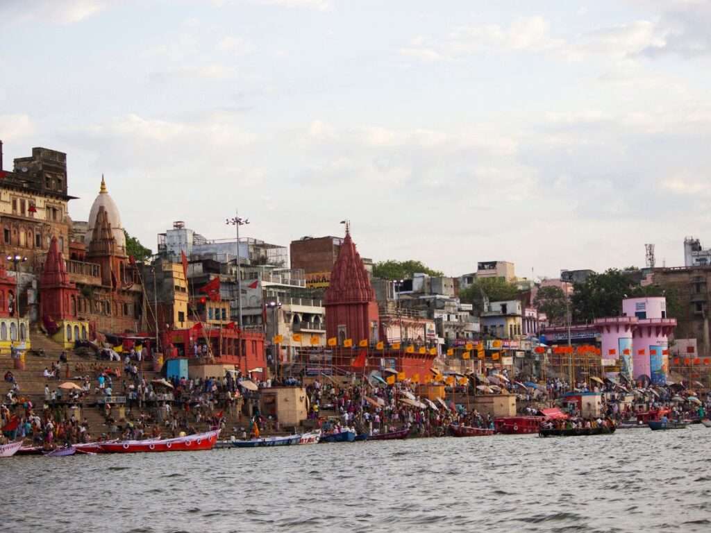 "View of the vibrant Dashashwamedh Ghat, one of the most iconic Varanasi ghats, with pilgrims performing rituals along the Ganges River."




